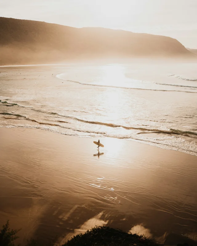 A surfer at sunset in Imsouane
